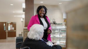 A staff worker and resident at BirchPointe, a skilled nursing facility, talking and smiling together