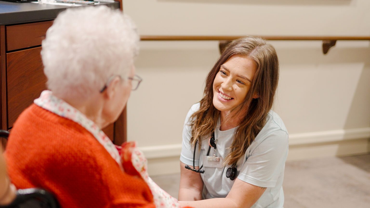 A nurse smiling at a resident of BirchPointe, a nursing home