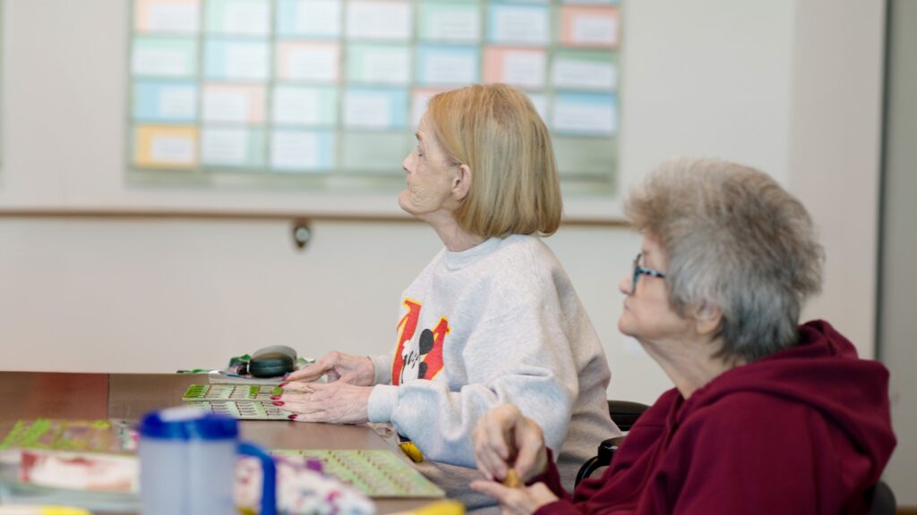Two women playing bingo at a skilled nursing facility